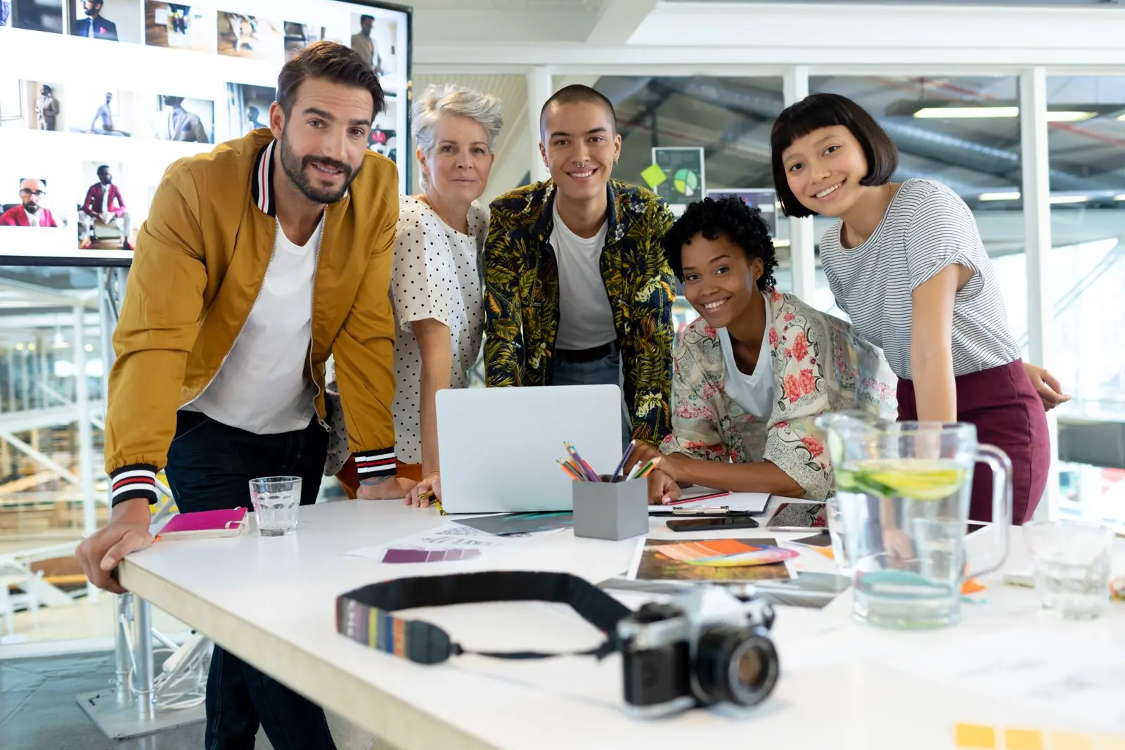 Split image of a freelance web designer working alone and an agency team meeting around a table