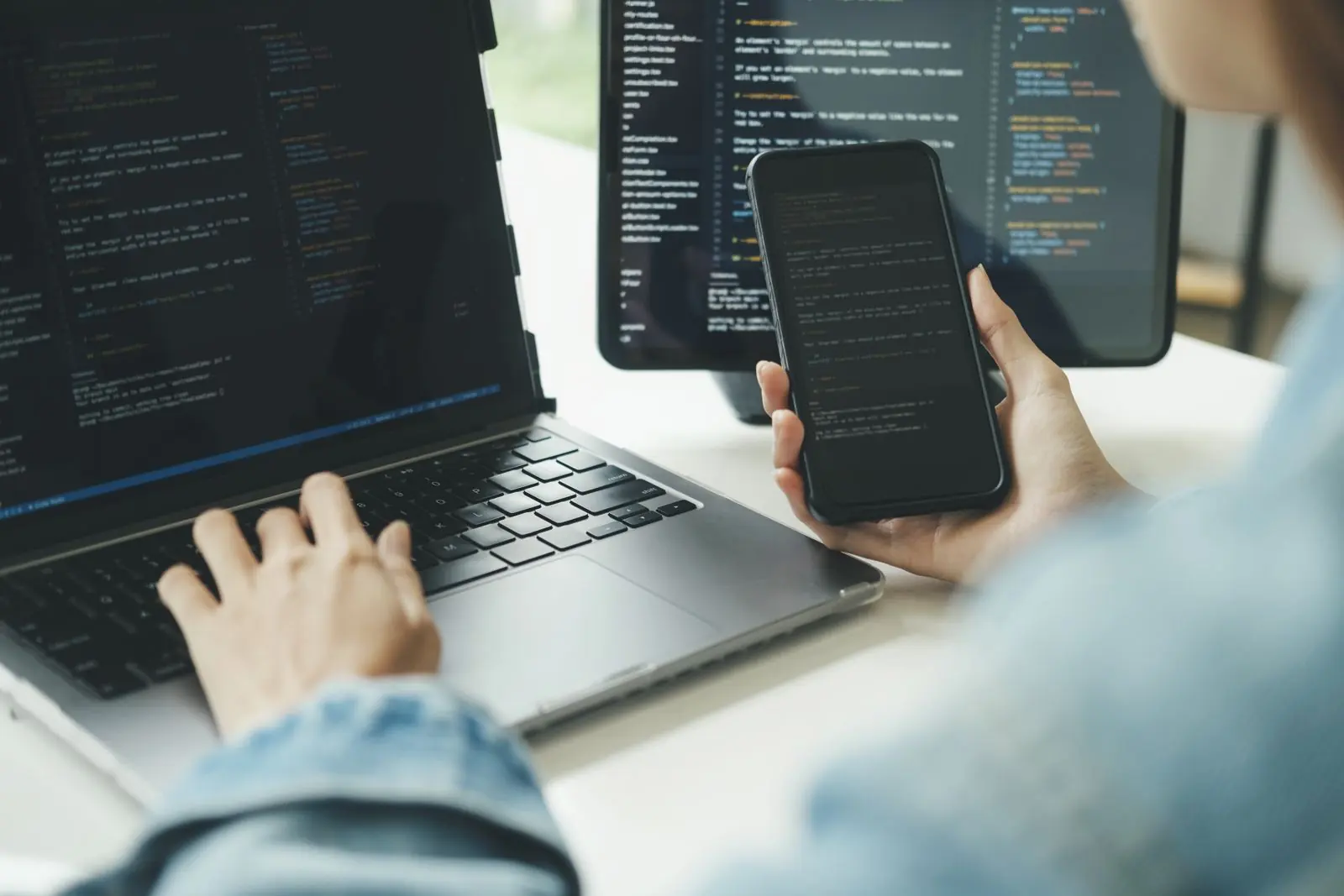 Person holding an iPhone and an Android phone running the same business app