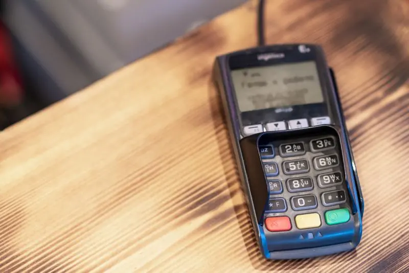 Checkout screen showing multiple payment methods with a card reader on the counter