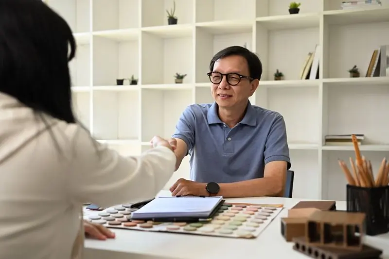 Client and web designer in a meeting with a notebook of questions on the table