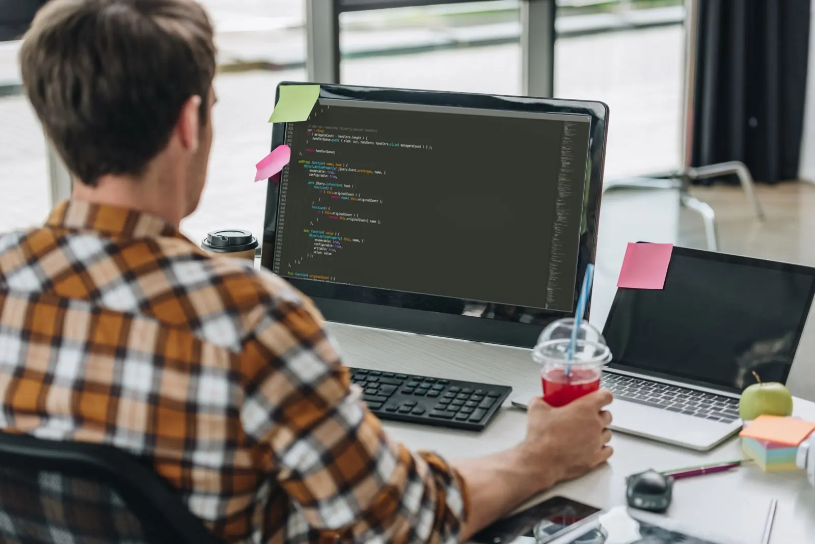 Developer ticking items on a website maintenance checklist beside a screen showing a WordPress dashboard
